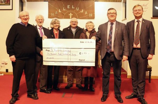 Partick South minister Rev Andy McIntyre and St Thorlak's Community leader Steven Owens accept the cheque from representatives of Netherlee and Stamperland Chur