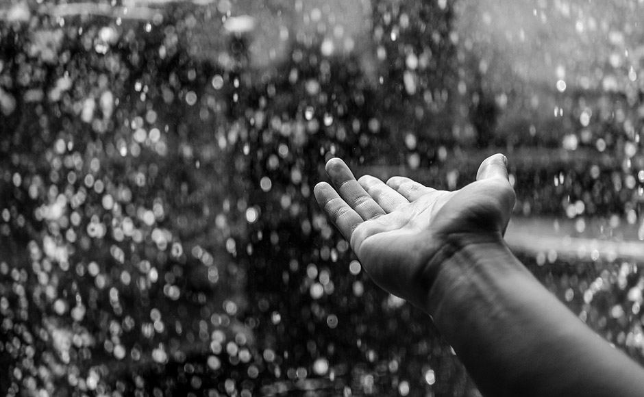 hand reaching into rain