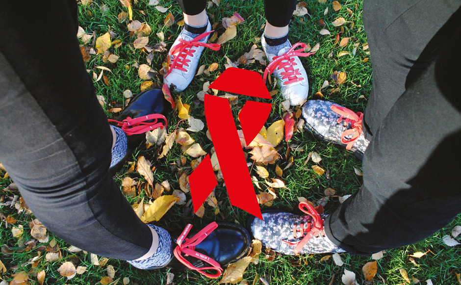 People wearing running shoes standing together around an AIDS ribbon graphic