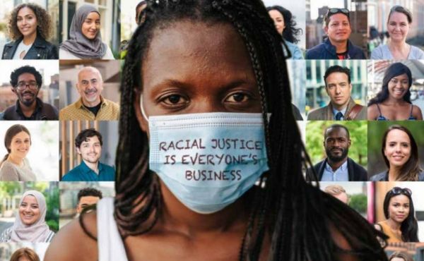 A woman with a face mask on that reads racial justice is everyone's business