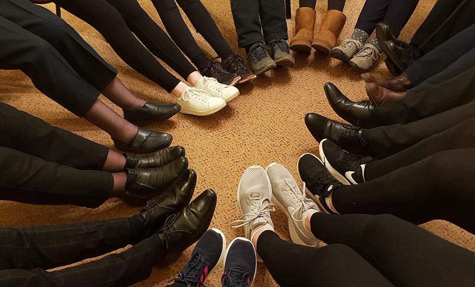 Group of people with their feet in a circle shape