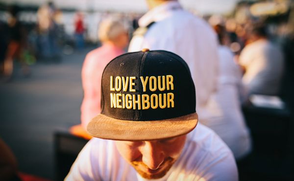 Man wearing a love your neighbour hat