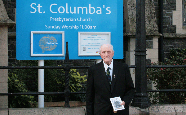 Ex-serviceman Sandy Wright holding the photo of him and his friend Scott during his national service days in the 1950s.
