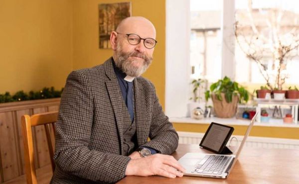 Rev Alastair Duncan seated with a laptop