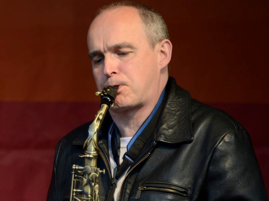 Rev Dr Robin Hill playing a saxophone