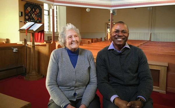 Elijah Odinna and Ann Jackson sitting in a church