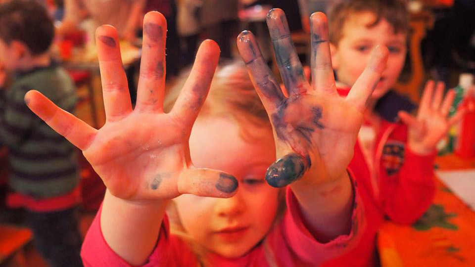 Children playing with paint at Messy Church in Murrayfield Parish Church