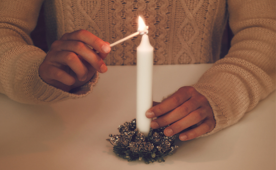 A lady's hands lighting a candle for Advent