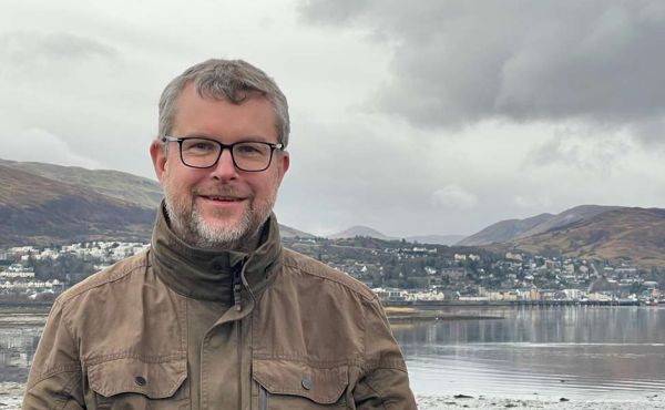 Rev David Sim with his new parish of Fort William in the background