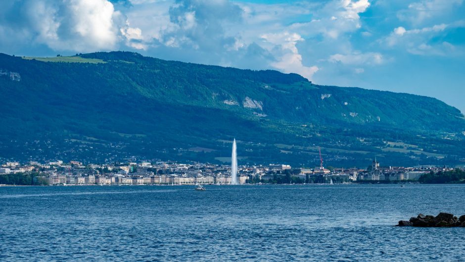 Geneva with the water at the forefront and green hills behind.