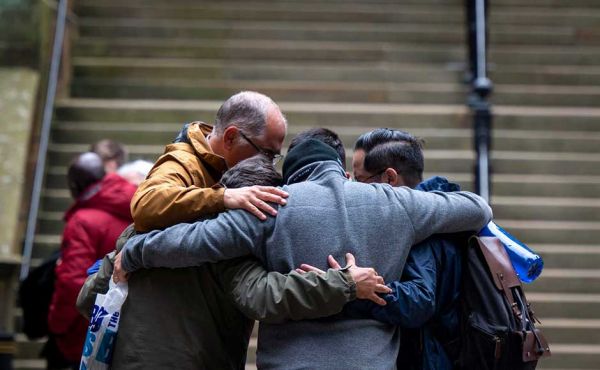 Group of people embracing outside Assembly Hall